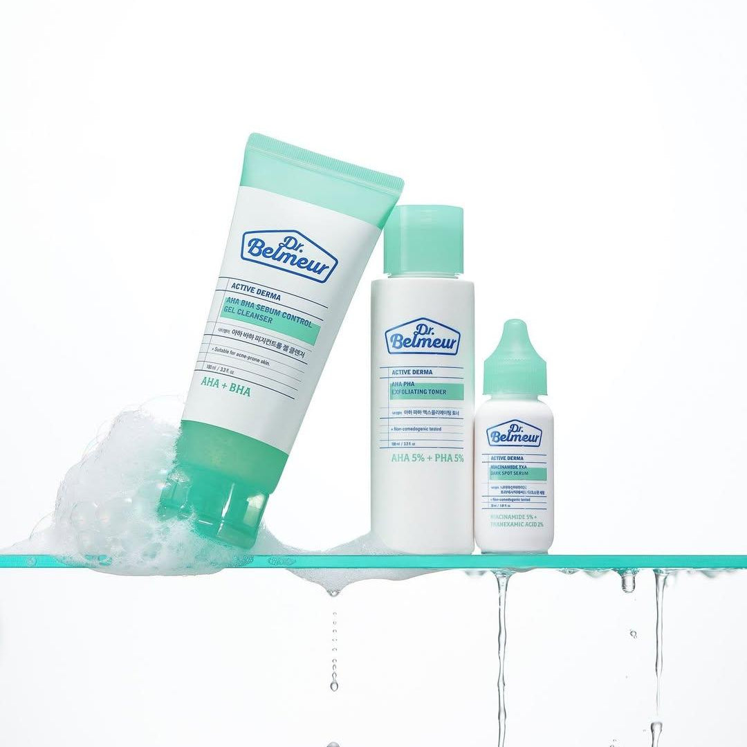 Dr. Belmew skincare products on a glass shelf with water droplets.